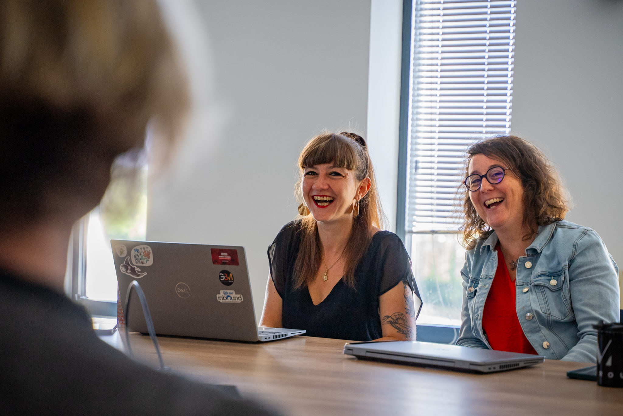 Deux collaboratrices rient pendant une réunion de l'équipe Winbound