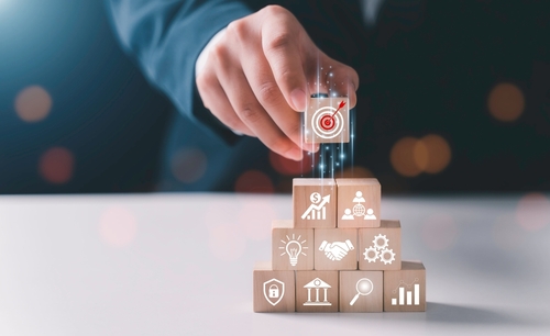 main prenant un cube en bois avec une cible dessinée dessus