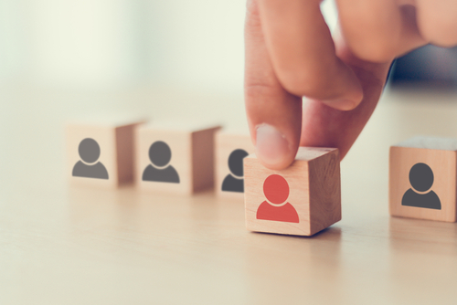 une main sélectionne un cube en bois spécifique